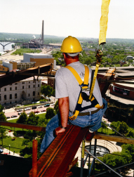 Construction worker sitting on a beam